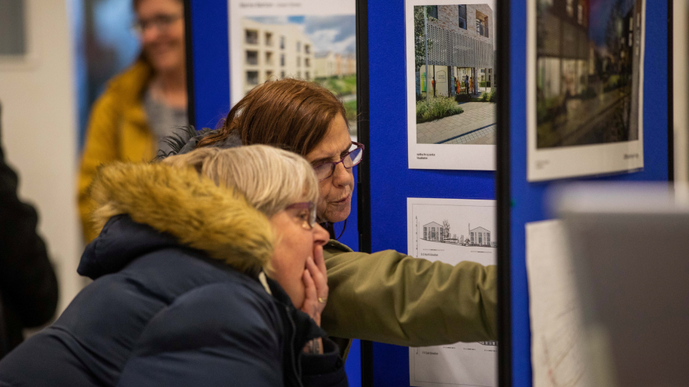 Two people examining an information board